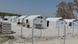 Tents behind a barbed fence in a refugee camp in Greece Tents behind a barbed fence in a refugee camp in Greece