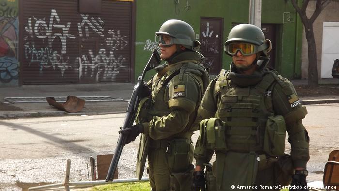 Dos carabineros, policías militares chilenos, fuertemente armados.