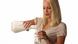 Frau giesst sich aus einer Karaffe ein Glas Milch ein Frau giesst sich aus einer Karaffe ein Glas Milch ein