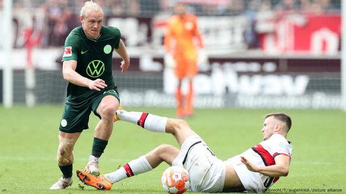 Wolfsburgs Xaver Schlager dribbelt um den am Boden liegenden Sasa Kalajdzic vom VfB Stuttgart herum