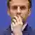 Emmanuel Macron com os dedos sobre a boca e com expressão de preocupação