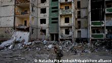 19.06.2022, Ukraine, Tschernihiw: Ein Soldat geht an einem durch Angriffe zerstörten Gebäude vorbei. Foto: Natacha Pisarenko/AP/dpa +++ dpa-Bildfunk +++