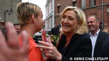 French far-right party Rassemblement National (RN) leader Marine Le Pen speaks with a woman after casting her vote in the second stage of French parliamentary elections at a polling station at Henin-Beaumont, northern France on June 19, 2022. (Photo by DENIS CHARLET / AFP)