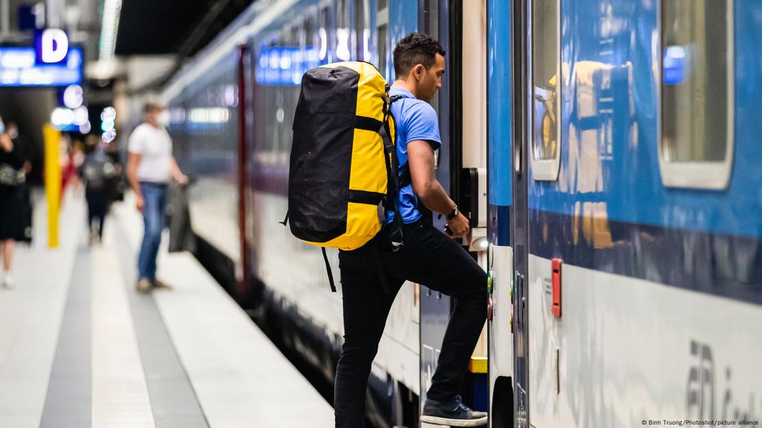 Homem com mochila embarca em trem