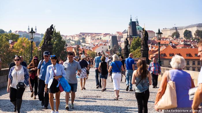 Tourists walk over the Charles Bridge in Prague