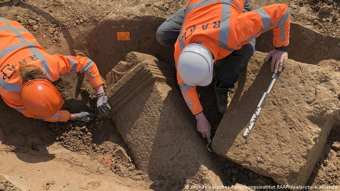 Archaeological teams measure and dig up altar stones from a Roman temple site near Nijmegen in the Netherlands