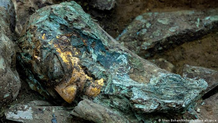 Artefactos que incluyen una cabeza de bronce con máscara de oro excavada en la fosa de sacrificios número 8 del yacimiento de las ruinas de Sanxingdui, en la provincia suroccidental china de Sichuan.