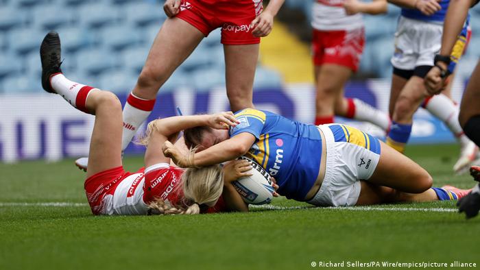 A woman pictured scoring a try during a rugby match