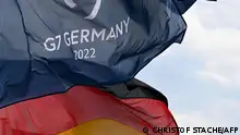 A German national flag and a flag for the G7 Summit fly in the wind in Garmisch-Partenkirchen, southern Germany on June 20, 2022, a few days ahead of the start of the G7 Summit in Elmau. - Germany will host the G7 summit at Castle Elmau Hotel from June 26 until June 28, 2022. (Photo by Christof STACHE / AFP)