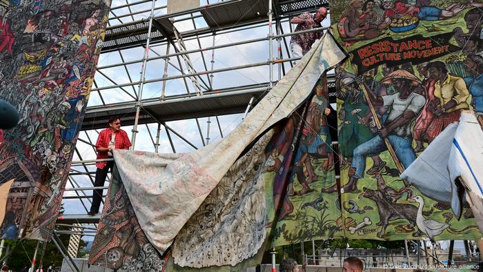 Men on scaffolding taking down a large banner