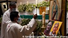 A priest blesses the photos of Jesuit priests Javier Campos Morales, left, and Joaquin Cesar Mora Salazar during a Mass to mourn them, at a church in Mexico City, Tuesday, June 21, 2022. The two elderly priests were killed inside a church where a man pursued by gunmen apparently sought refuge in a remote mountainous area of northern Mexico, the religious order’s Mexican branch announced Tuesday. (AP Photo/Fernando Llano)