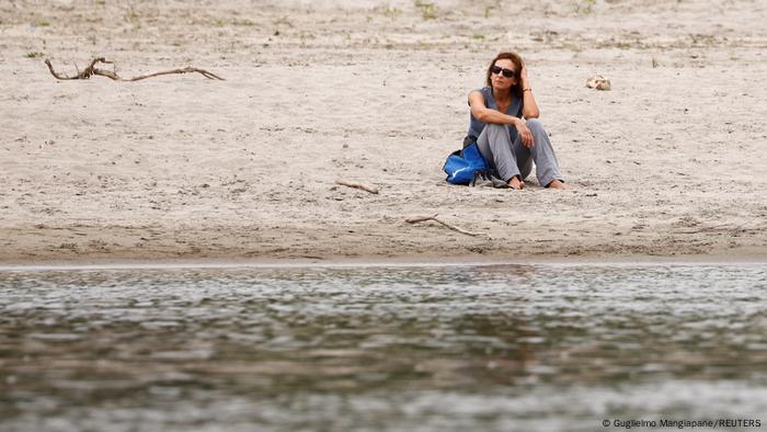 A woman sits on Po's dry riverbed