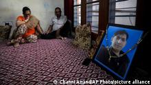 India Kashmir Hindus in Mourning - Usha Bhat, left, and Bitta Ji Bhat mourn by a photograph of their son Rahul Bhat at their residence in Jammu, India, June 11, 2022. Rahul Bhat, a Hindu revenue clerk, was fatally shot inside his office in Kashmir Valley in May. Two days later, police said they had shot dead the anti-India rebels responsible in a gunfight. That hasn't eased the deep mourning of Bhat's parents who have yet to reconcile with the death of their son. (AP Photo/Channi Anand)
