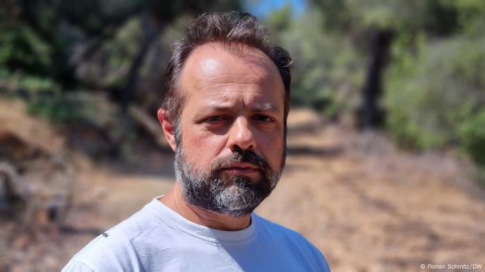 Elias Tziritis of WWF Greece stands on a road in the woods 