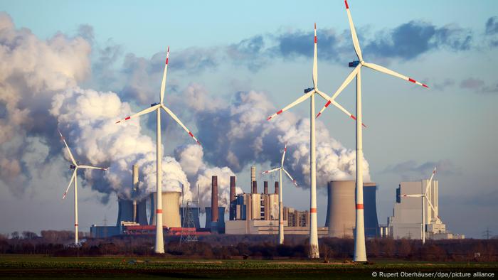 Windenergieanlagen vor dem qualmenden und dampfenden Kohlekraftwerk Neurath zwischen Köln und Mönchengladbach