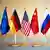 Flaggen der EU, von Deutschland, den USA, China und Russland stehen auf einem Tisch