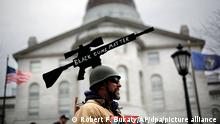 14.04.2018, USA, Augusta: Ein Mann trägt eine Nachbildung eines taktischen Gewehrs als auf einem Helm, während einer Demonstration für ein Recht auf Waffen. Befürworter von Waffen haben sich versammelt, um den Demonstrationen gegen Waffengewalt und schärfere Waffengesetzte entgegen zu wirken. Foto: Robert F. Bukaty/AP/dpa +++ dpa-Bildfunk +++