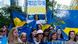 People gathered outdoors in Brussels holding a sign reading "Proud to be Ukrainian" People gathered outdoors in Brussels holding a sign reading "Proud to be Ukrainian"
