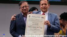 Colombian President-elect Gustavo Petro, left, holds the document that certifies him as president embraced by Luis Guillermo Perez, a magistrate of the National Electoral Council, during a ceremony that certifies his victory, in Bogota, Colombia, Thursday, June 23, 2022. (AP Photo/Fernando Vergara)
