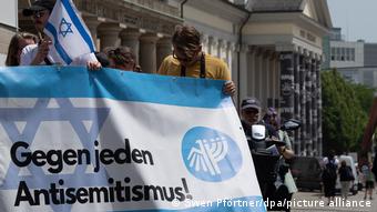 Menschen halten vor dem Eingang des Museums Fridericianum ein Plakat mit der Aufschrift Gegen jeden Antisemitismus!.