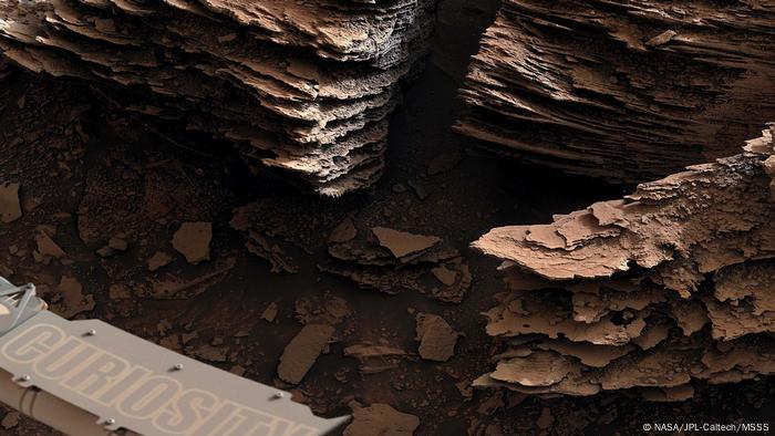 El róver Curiosity de la NASA capturó esta vista de las rocas en capas y escamas que se cree que se formaron en un antiguo lecho de arroyo o un pequeño estanque.