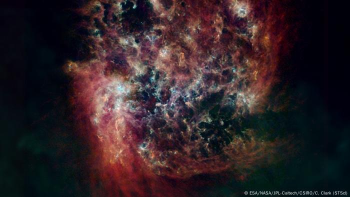 La Gran Nube de Magallanes (LMC) es un satélite de la Vía Láctea que contiene unos 30.000 millones de estrellas. El polvo frío y caliente de la LMC se muestra en verde y azul, respectivamente, y el gas de hidrógeno en rojo.