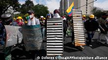 Demonstrators march with makeshift shields during protests against President Guillermo Lasso's economic policies and a demand to cut fuel prices, in downtown Quito, Ecuador, Friday, June 24, 2022. (AP Photo/Dolores Ochoa)