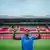 Taiwo Awoniyi stands on a football pitch, holding up both hands and pointing to the sky