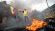 Manifestante segura bandeira do Equador diante de fogo em rua de Quito Manifestante segura bandeira do Equador diante de fogo em rua de Quito