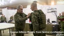 In this image taken from video released by Russian Defense Ministry Press Service on Sunday, June 26, 2022, Russian Defense Minister Sergei Shoigu, foreground left, awards a Russian serviceman while inspecting the Russian troops participating in a special military operation in Ukraine. (Russian Defense Ministry Press Service via AP)