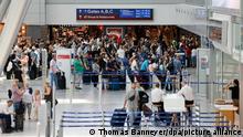 24.06.2022, Nordrhein-Westfalen, Düsseldorf: Passagiere stehen an Check-In Schalter der jeweiligen Airlines am Flughafen Düsseldorf an. Als erstes Bundesland startet NRW in die Sommerferien. Foto: Thomas Banneyer/dpa +++ dpa-Bildfunk +++