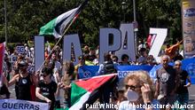 Protesters walk with large letters reading 'Peace' during an anti NATO demonstration march ahead of the 2022 NATO Summit in Madrid, Spain, Sunday, June 26, 2022. (AP Photo/Paul White)