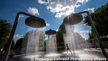 A boy cools off in a public fountain in Vilnius, Lithuania, Sunday, June 26, 2022. The heat wave continues in Lithuania as temperatures rise to as high as 32 degrees Celsius (89.6 degrees Fahrenheit). (AP Photo/Mindaugas Kulbis)