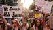 Manifestantes pró-aborto em Nova York em passeata seguram cartazes com mensagens e defesa das mulheres
