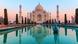 The Taj Mahal: A large, white temple with many towers, reflected in a body of water in the rosy morning light. The Taj Mahal: A large, white temple with many towers, reflected in a body of water in the rosy morning light.