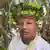 Adriano Karipuno, law student, Amazon, wears a headdress and looks into the camera