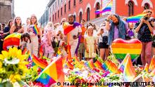 People bringing flowers and rainbow flags as tributes to victims of Saturday's shooting