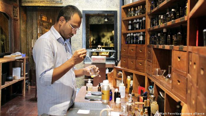 Ein Parfümeur mit kleinen Fläschchen und Gläsern in Singapur