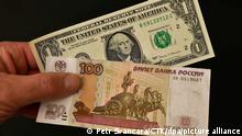 Банкнота 100 рублей на фоне банкноты доллара США 