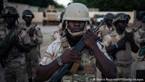Des soldats procèdent à la cérémonie quotidienne de descente du drapeau au secteur n° 1 de la Force multinationale mixte (FMM) basé à Mora, dans la région de l'Extrême-Nord du Cameroun