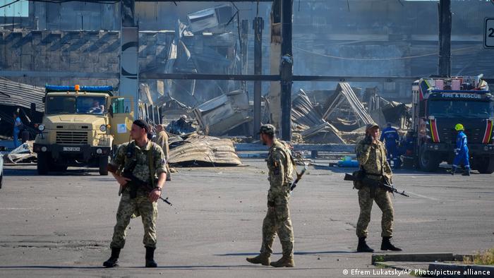 Украинские военные охраняют ТЦ Амстор после ракетного обстрела