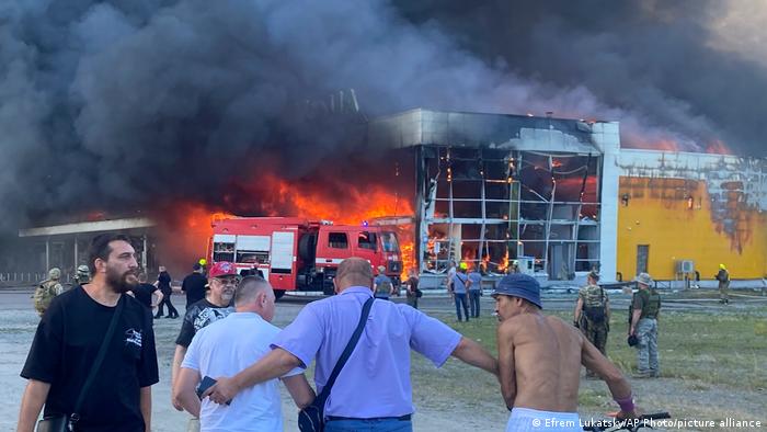 Ukrainians outside a burning shopping center in Kremenchuk following a Russian missile strike