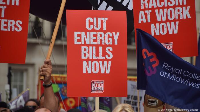 A Cut energy bills now placard is seen during a demonstration of thousands of people 