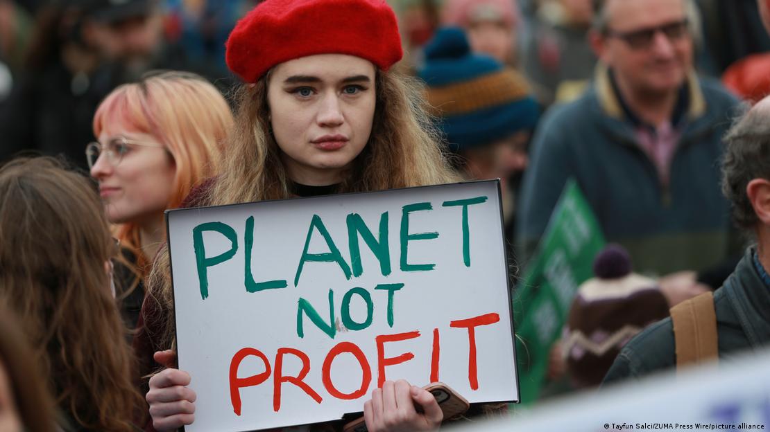 Ativista segura cartaz com os dizeres "Planeta em vez de lucros" durante manifestação contra as mudanças climáticas na Trafalgar Square, em Londres, em 6 de novembro de 2021.