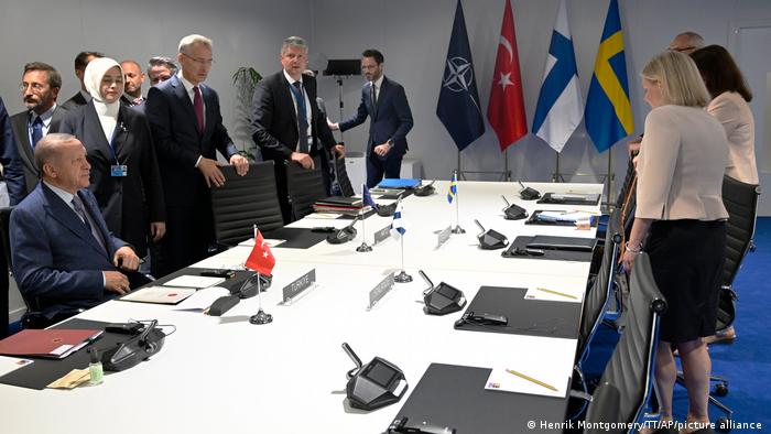 Turkey's President Erdogan remains seated as Swedish Prime Minister Magdelena Andersson (r) and her team arrive in Madrid for negotiations brokered by NATO Secretary-General Jens Stoltenberg (c).