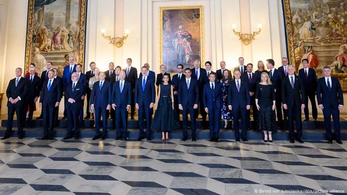 NATO leaders posing in a room with paintings