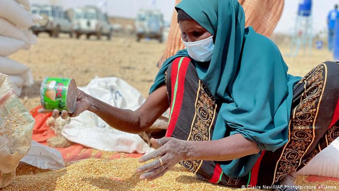 Eine Frau verteilt eine Maislieferung des UN-Welternährungsprogramms