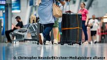 Ferienbeginn am Flughafen Düsseldorf, Flugreisende fliegen in den Urlaub und müssen in langen Warteschlangen stehen,