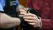 A police officer holds another man's hands as he removes his handcuffs A police officer holds another man's hands as he removes his handcuffs