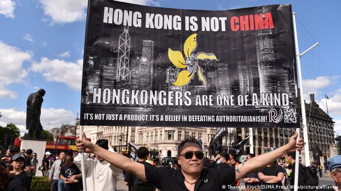 In London, a man demonstrates with a banner for more democracy in Hong Kong